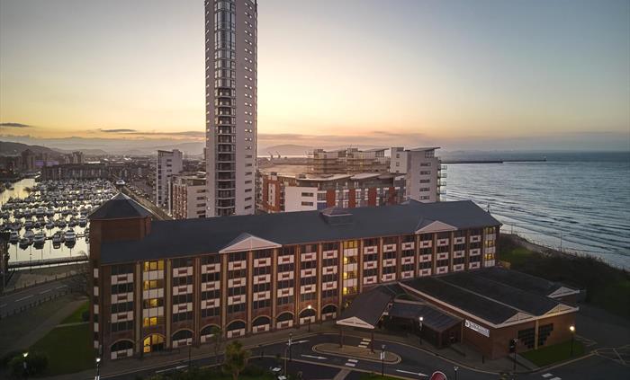 A beautiful view of Delta Hotels by Marriott Swansea with the marina and sea view in the distance. This stunning picture was taken at dawn.